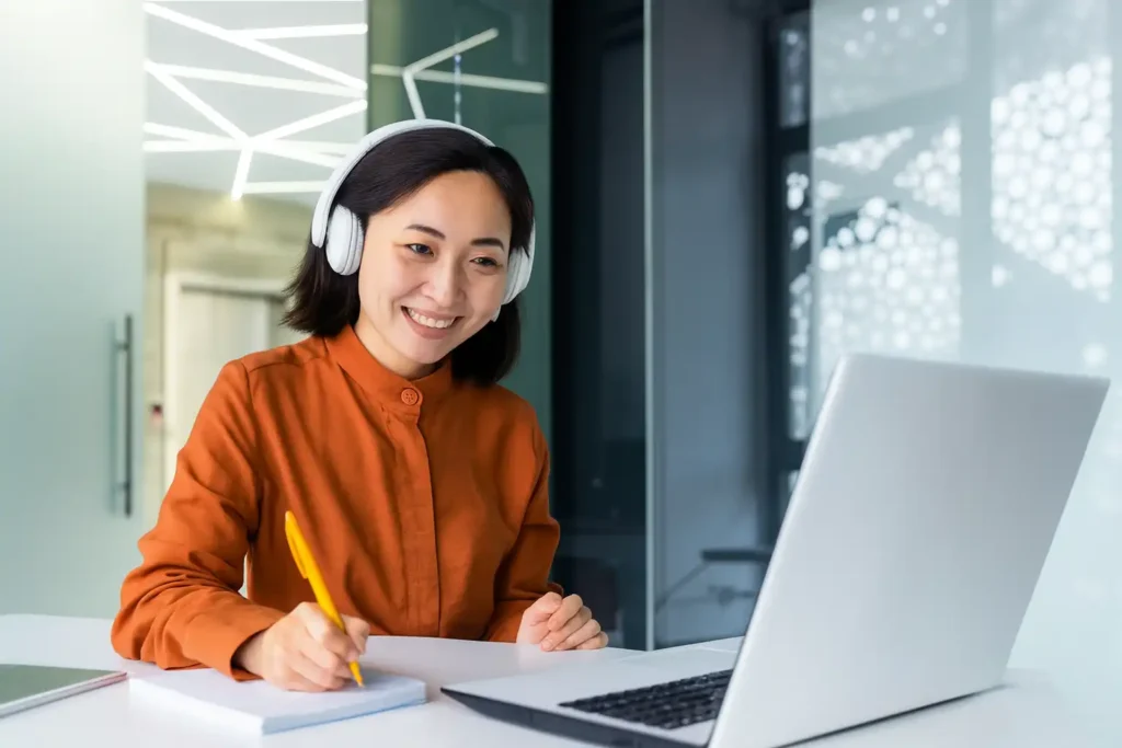 中翻外的翻译员正在远程工作，一位亚洲女性佩戴耳机对着电脑笔记，象征专业人工翻译流程
